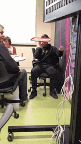a man sitting in a chair holding a tray in front of his face