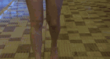 a woman in a bikini stands in front of a swimming pool