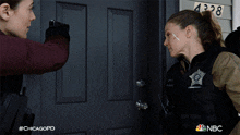 a woman is being arrested by police officers in front of a house with the number 4328 on it