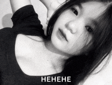 a black and white photo of a girl with the word henehe on the bottom right