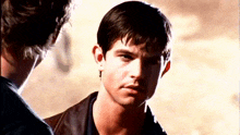 a close up of a man 's face with another man behind him