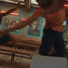 a man is doing a handstand in a room with pictures on the walls