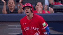 a baseball player wearing a red blue jays shirt