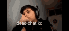 a young boy wearing headphones with the words dead chat xd written on the bottom