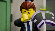 a lego man in a suit and tie is holding a pair of purple shoes