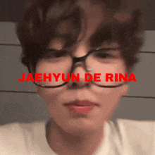 a close up of a person wearing glasses with the name jaehyun de rina in red letters