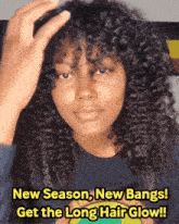 a woman with curly hair is wearing a blue shirt that says new season new bangs get the long hair glow !!