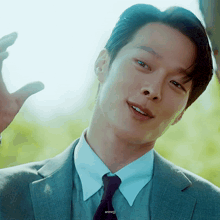 a close up of a man in a suit and tie with the name anneji written below him