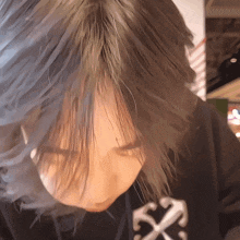a close up of a person 's face with a black shirt with a white x on it