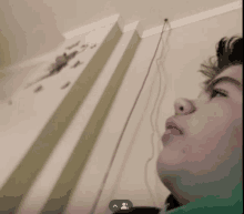 a young boy looks up at a clock on a wall