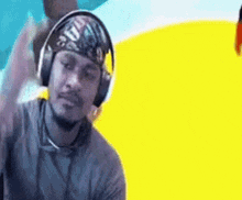 a man wearing headphones and a bandana on his head is waving .