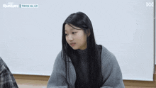 a girl is sitting in front of a white board that says runup