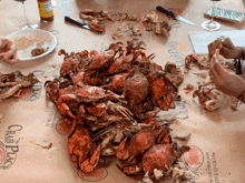 a bunch of crabs on a table with crab place written on the table cloth