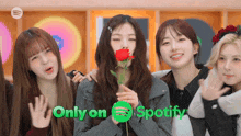 a group of girls are posing for a picture with spotify in the background