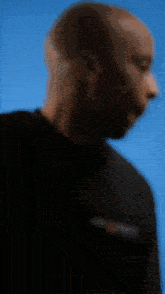 a blurry picture of a man wearing a black t-shirt with the word s on it