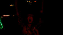 a person is screaming in the dark with green lights behind them