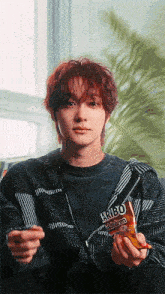 a young man is holding a bag of haribo