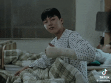a man in a hospital gown with a bandage on his arm is laying in bed