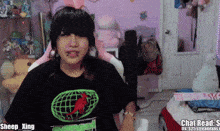 a girl wearing a shirt that says sheep xing is sitting in a chair