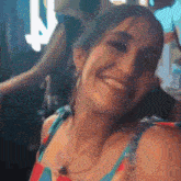 a woman in a blue and red striped top smiles for the camera