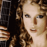 a woman with curly hair is holding a guitar in her hand