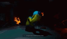 a cartoon character is standing in a dark room with fires behind him .