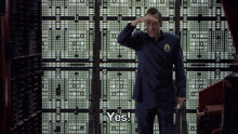 a man in a suit says yes in front of a wall