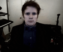 a man in a suit and bow tie is standing in front of a keyboard