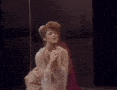 a woman in a white dress is singing into a microphone on a stage