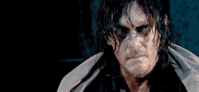 a man with wet hair and a beard looks at the camera with a serious look on his face