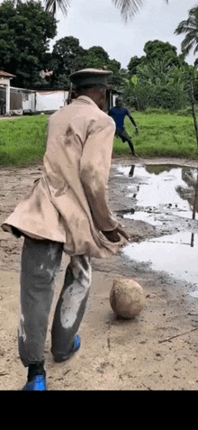 a man is playing soccer in a muddy field .