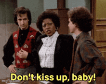 a man and a woman are standing next to each other and the woman says do n't kiss up baby .