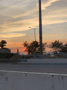 a sunset over a highway with a sign that says emergency exit