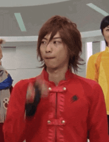 a man wearing a red jacket is making a funny face