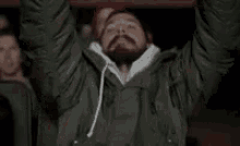 a man with a beard is listening to music with headphones while sitting in a theater .