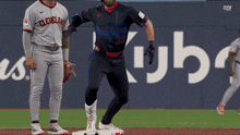 a baseball player wearing a cleveland jersey is standing on the base