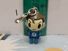 a keychain of a superhero with the number four on his shirt