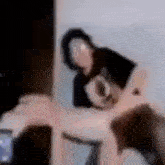 a blurry picture of a person holding another person 's arm .