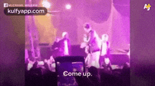 a group of people standing on top of a stage in front of a crowd .