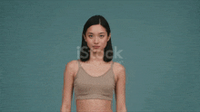 a woman in a sports bra flexes her muscles