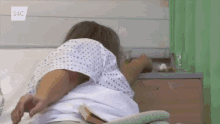 a woman in a hospital gown is laying in a hospital bed