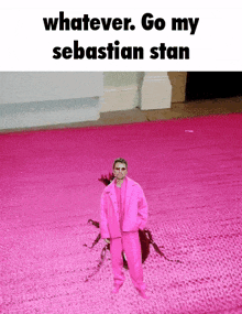 a man in a pink suit is standing in a pink carpet