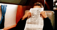 a man is reading a newspaper that says cellular phone