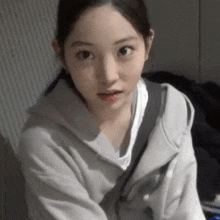 a close up of a woman wearing a gray hoodie