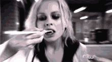 a woman is brushing her teeth with a toothbrush and toothpaste .