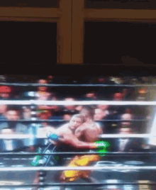 a blurry photo of a boxing match with a crowd watching