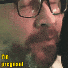 a close up of a man 's face with the words " i 'm pregnant " in yellow