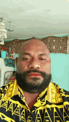 a man with a beard is wearing a yellow and black shirt that says vava
