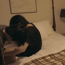 a man and a woman are laying on a bed with a map on the wall behind them