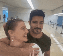 a man and a woman are posing for a photo in a hallway